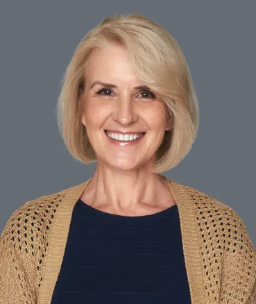 A smiling woman showing a complete upper arch of teeth